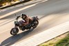 Above angle of a person riding a motorcycle on a city street.