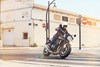 Three-quarter front angle of a person riding a motorcycle on a rural street.