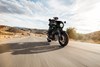 Three-quarter front angle of a person riding a motorcycle on a highway.