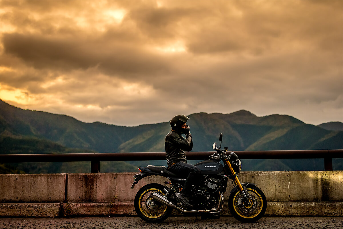 Side angle of a person seated on a parked motorcycle.