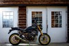 Side angle of a motorcycle parked in front of a building.