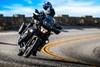 Front angle of a person and a passenger riding a motorcycle on a highway.