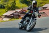 Three-quarter front angle of a person riding a motorcycle on a highway.