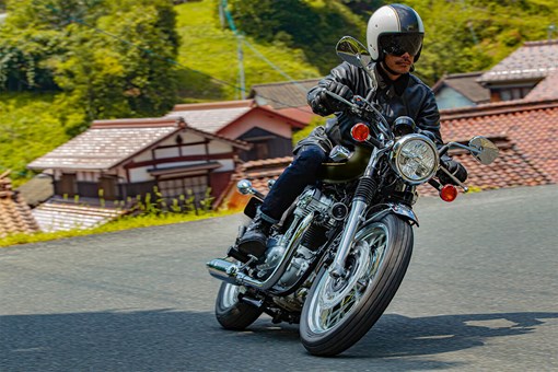 Three-quarter front angle of a person riding a motorcycle on a highway. opens in a new window