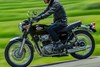 Side angle of a person riding a motorcycle on a highway.