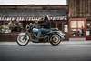 Side angle of a person riding a motorcycle through town.