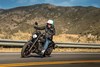 Three-quarter front angle of a person riding a motorcycle on a highway.