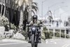 Front angle of a person riding a motorcycle on a city street.