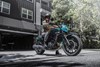 Side angle of a person stopped before pulling out into the street on a motorcycle.