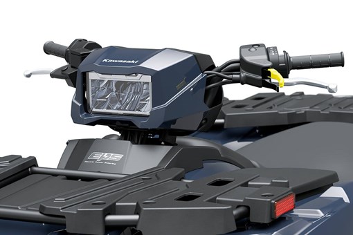 Close-up view of a handlebar-mounted headlight on an ATV. opens in a new window