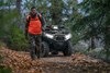 Front view of an ATV parked off-road with a person in the foreground.