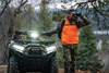 Front view of an ATV parked off-road with a hunter looking through binoculars.