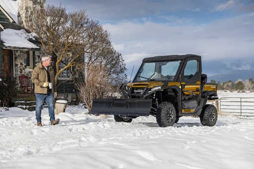 Front three-quarter view of a side x side with a snow plow attachment.  opens in a new window