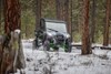 Front view of a person driving a side x side through the snow. 