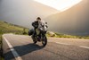 Three-quarter front angle of a person riding a motorcycle on a highway.