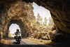 Front angle of a person riding a motorcycle through a tunnel.