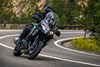 Three-quarter front angle of a person riding a motorcycle on a highway.