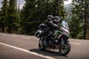 Profile angle of a person riding a motorcycle on a highway.