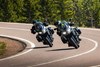 Front angle of people riding motorcycles on a highway.