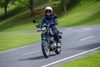 Front angle of a person riding a motorcycle on a road.