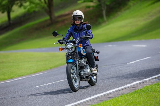Front angle of a person riding a motorcycle on a road. opens in a new window