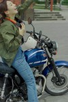 Profile angle of a person seated on a parked motorcycle.