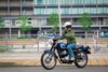 Profile angle of a person riding a motorcycle on the road.