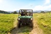 Front angle of a person driving a side x side off-road with two passengers.