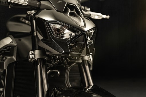Closeup view of motorcycle headlights in a dark studio. opens in a new window