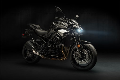 Profile angle of a motorcycle staged in a dark studio. opens in a new window
