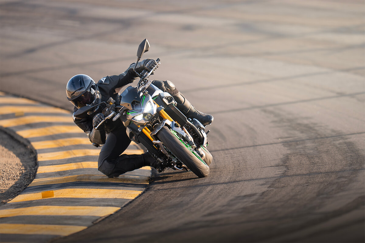 Front angle of a person dragging knee on a motorcycle on the track.