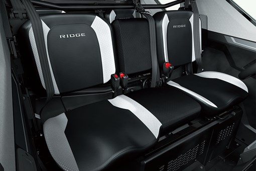 Interior view of front bench seating inside a side x side with central armrest up. opens in a new window