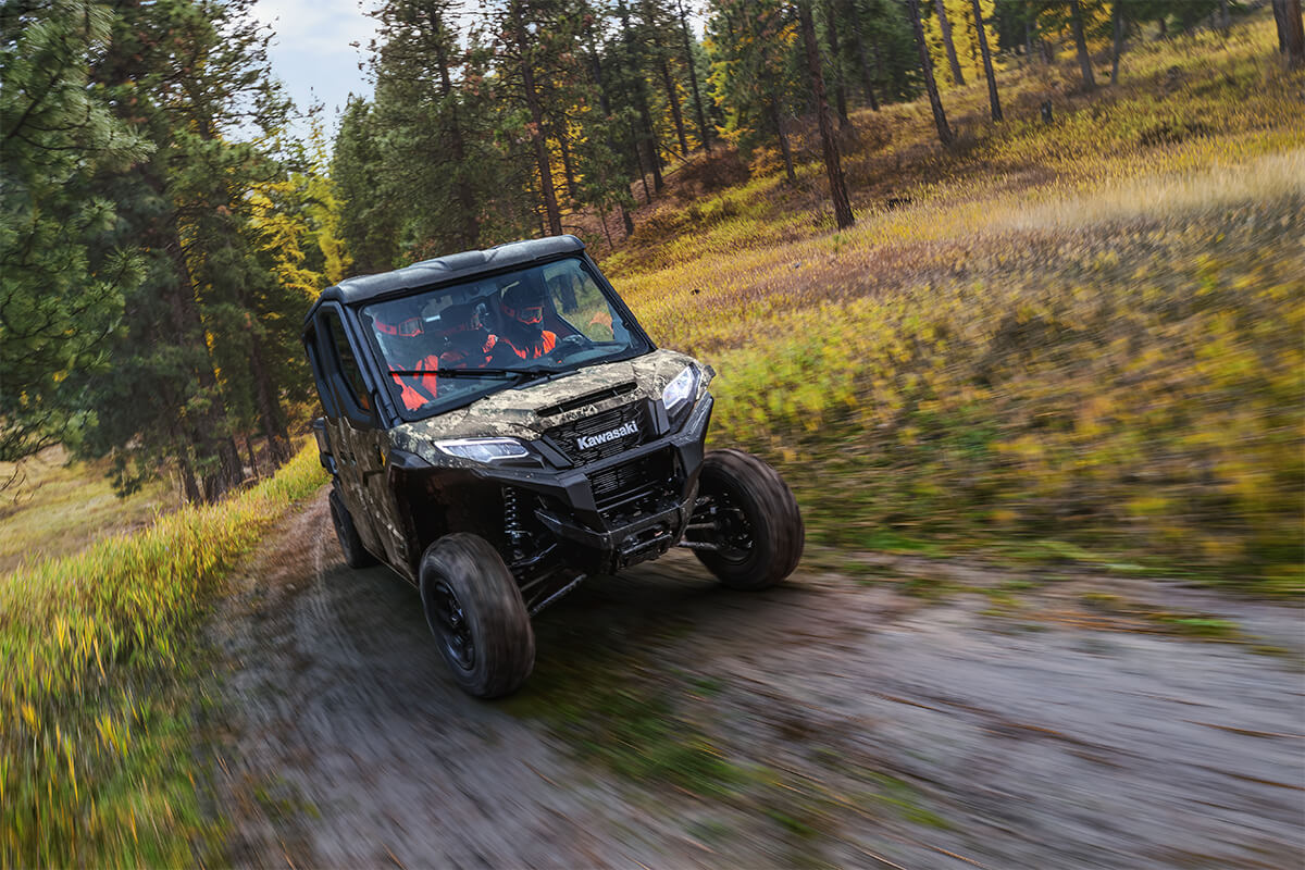 Oncoming view of a side x side driving on a muddy road.