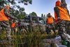 Hunters in orange vests preparing to climb into a side x side. 