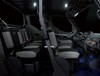 Profile view of interior of a side x side showing passenger seating in dark studio background.