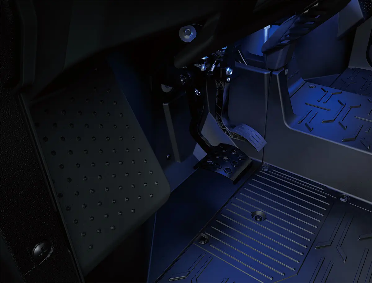 Interior view of foot controls of a side x side with lower accent lighting.