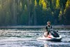 Front view of a person sitting on a personal watercraft in calm water. 