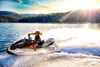 Side view of a woman on a personal watercraft on the water at sunset.