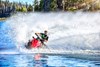 Front angle of a person riding a personal watercraft on the water.