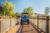 Front angle of a family riding in a Neighborhood Activity Vehicle over a bridge.