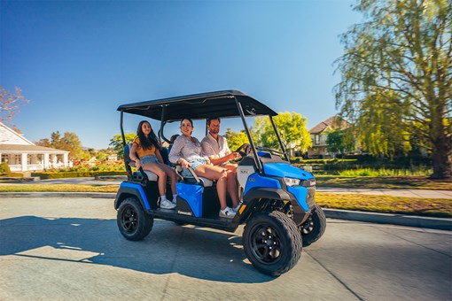 Side angle of a family riding in a Neighborhood Activity Vehicle on a community roadway. opens in a new window