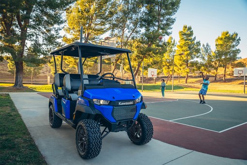 Three-quarter front angle of a Neighborhood Activity Vehicle parked near a basketball court. opens in a new window