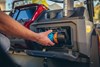 Close-up view of a person reaching for stored items in a storage compartment of a Neighborhood Activity Vehicle.