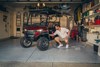 Three-quarter front angle of a person charging a Neighborhood Activity Vehicle inside a garage.