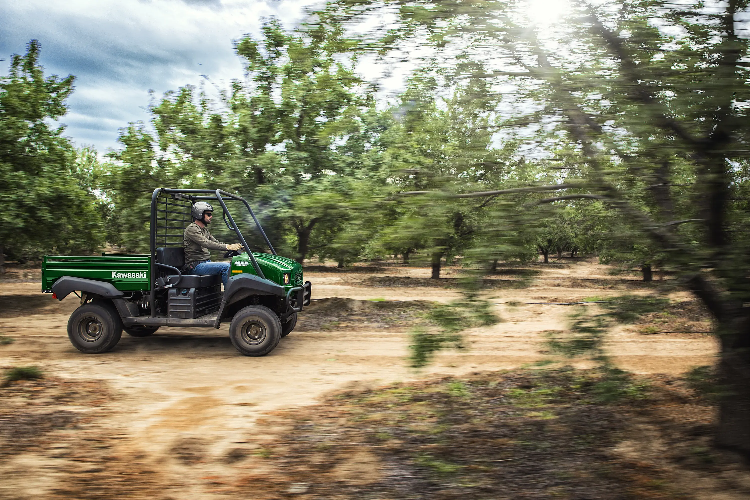 Side angle of a person driving a side x side on a ranch.
