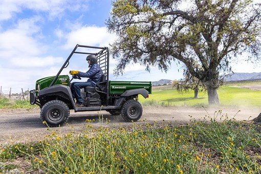 Side angle of a person driving a side x side at a ranch. opens in a new window