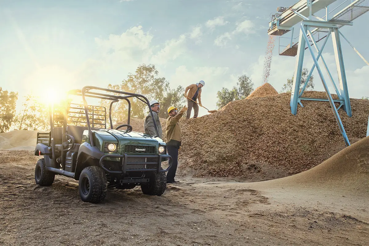 Three-quarter front angle of a green side x side parked off-road.
