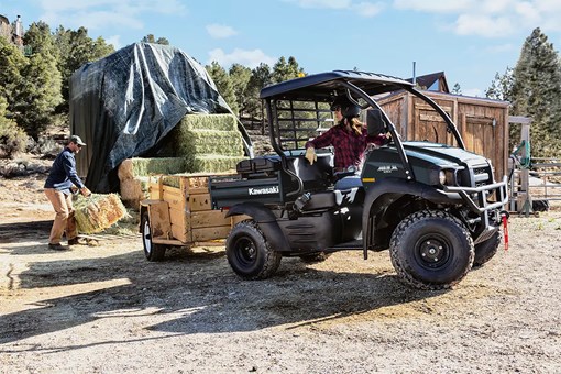 Profile angle of a person driving a side x side on a jobsite. opens in a new window