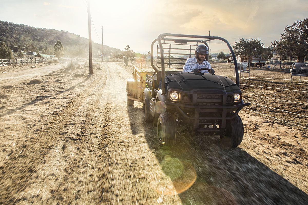 Front angle of a person driving a side x side on a ranch.