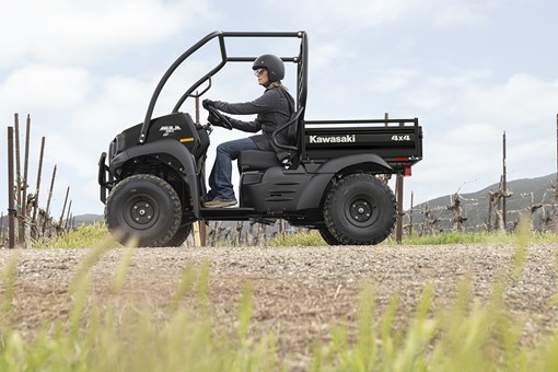 Side angle of a person driving a side x side on a ranch. opens in a new window